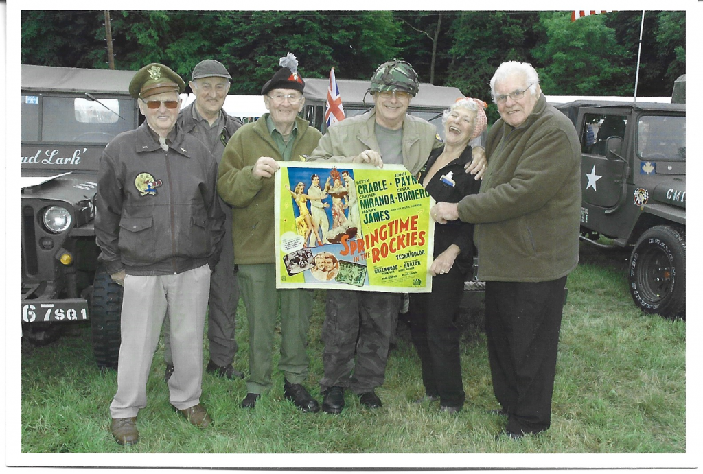 Men dressed in wartime clothing holding banner