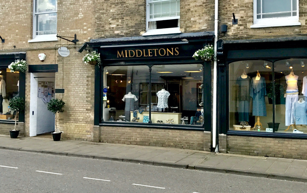 Black framed shop frontage with clothing in window displays