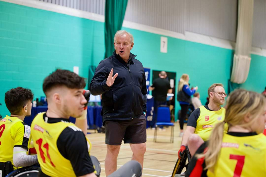 A coach talks to wheelchair rugby players