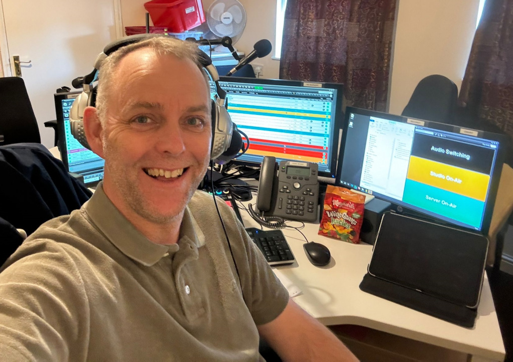 Smiling man at radio presenter desk